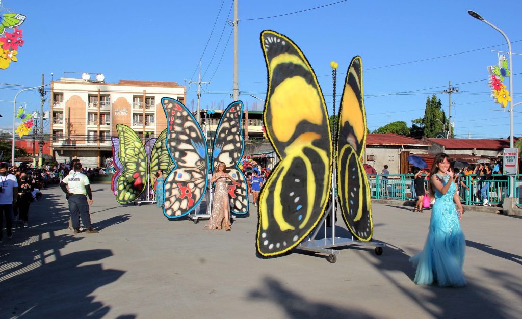 Paruparo Festival parade featuring colorful giant butterfly displays and festival performers in the street.