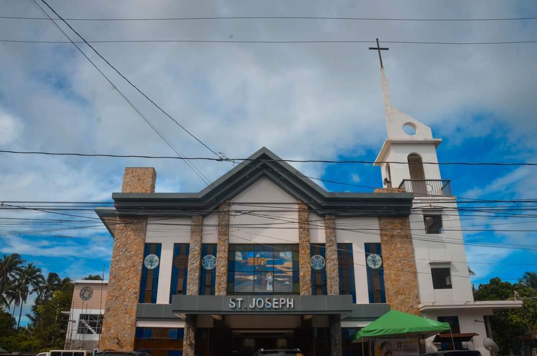 St. Joseph Parish in Alfonso, Cavite with a modern facade and bell tower against a blue sky.