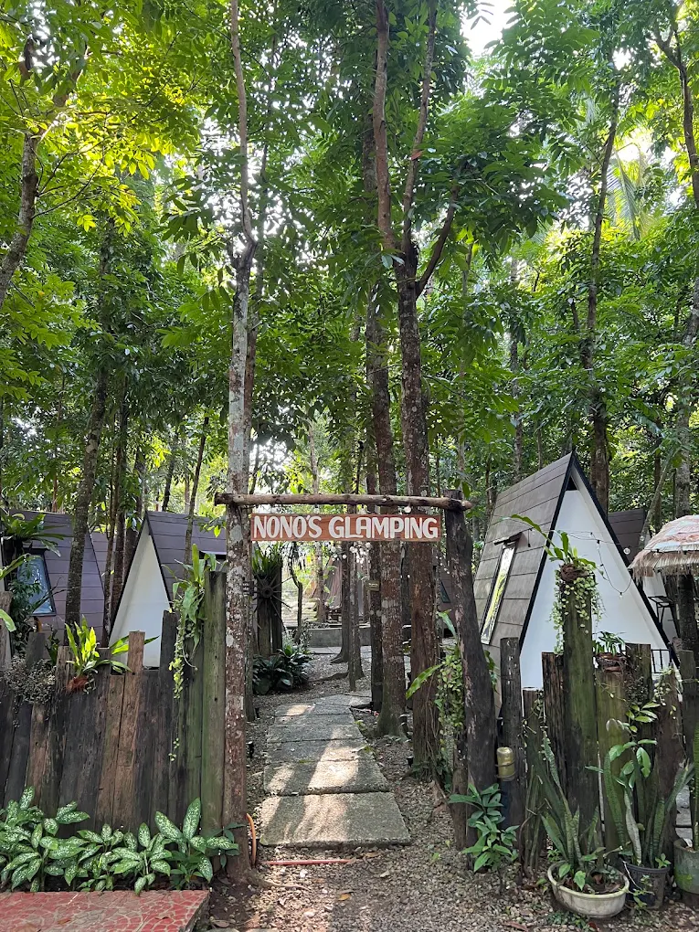 Glamping site entrance surrounded by lush trees at E-Place Resort & Leisure Farm, Magallanes.