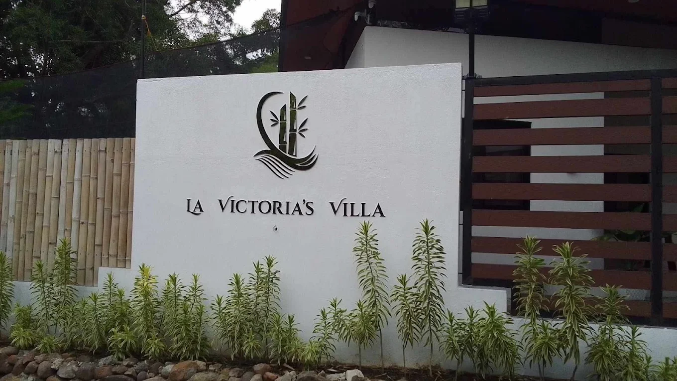 La Victoria's Villa entrance sign with plants in Maragondon, Cavite.