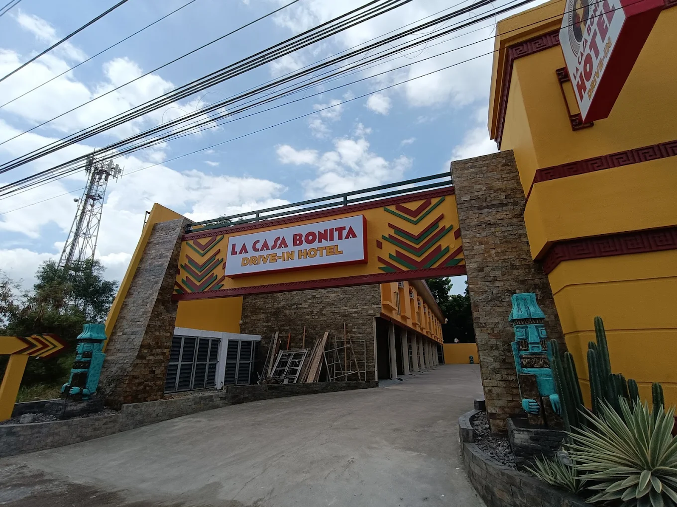 La Casa Bonita entrance in Alfonso, featuring vibrant yellow walls, decorative stonework, and a colorful sign.