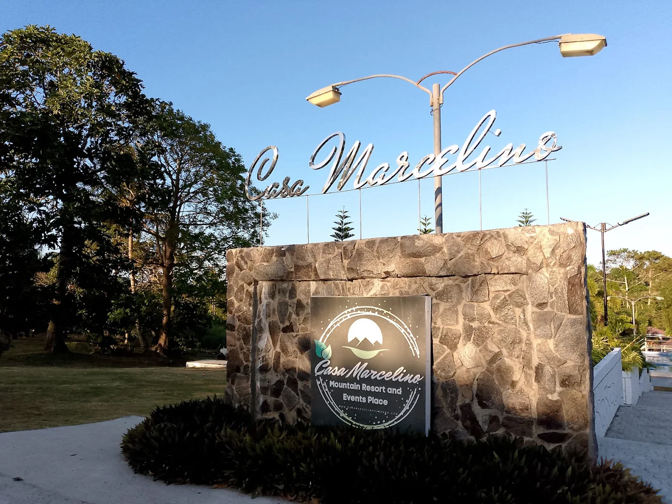 Casa Marcelino stone entrance sign with trees and clear blue sky in Alfonso, Cavite.
