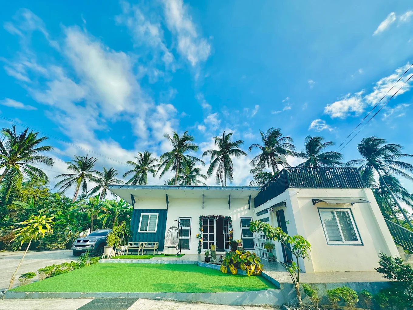 Zion's Private Villa in Alfonso, surrounded by palm trees and a clear blue sky, featuring a modern white building.