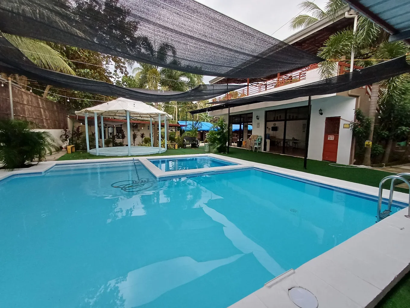 Outdoor pool area at Atanacio's Farm Resort & Event Place, Trece Martires, with gazebo and lush greenery.