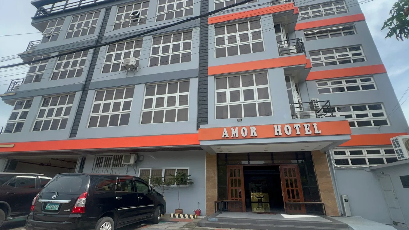 Amor Hotel building exterior with parked cars in Rosario, Cavite.