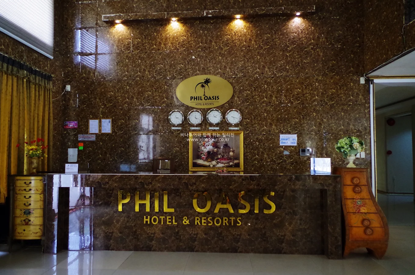 Phil Oasis Hotel and Resorts reception desk with marble decor and clocks in Silang, Cavite.