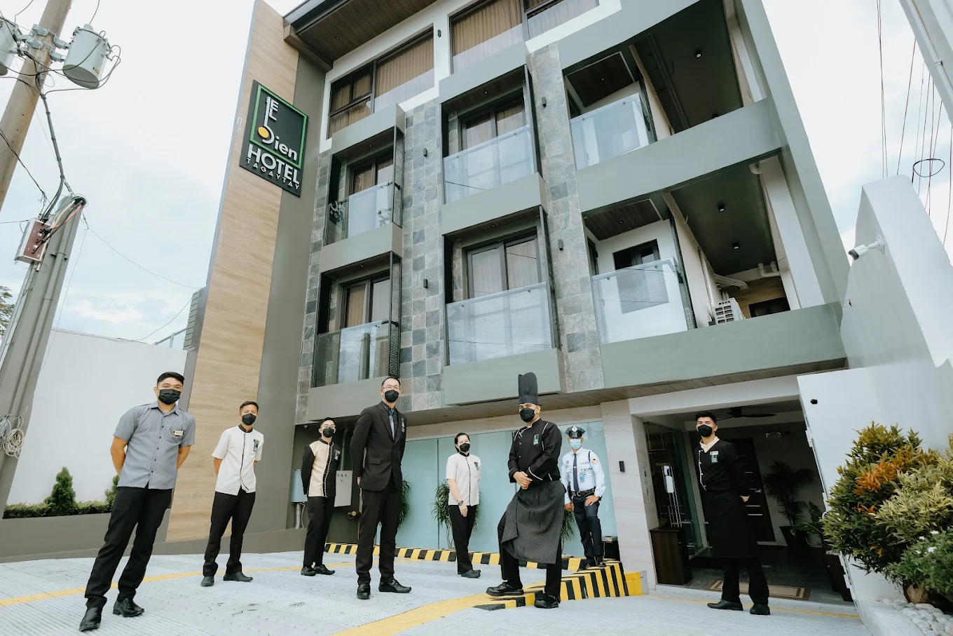 El Bien Hotel staff standing in front of the modern hotel building in Tagaytay, Philippines.