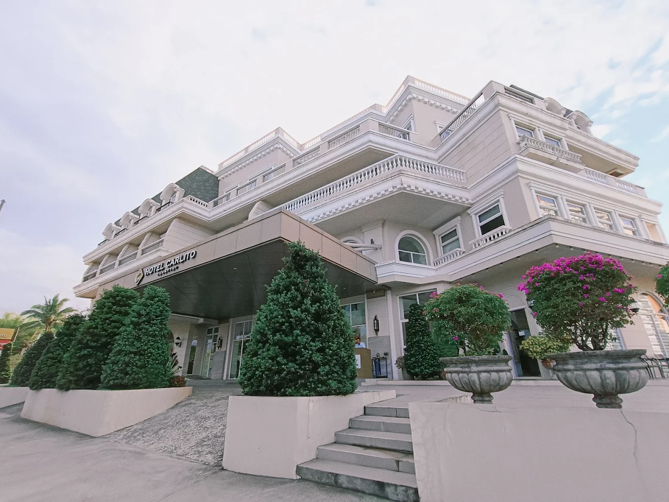 Elegant facade of Hotel Carlito Tagaytay with lush greenery and vibrant flowers in Tagaytay.