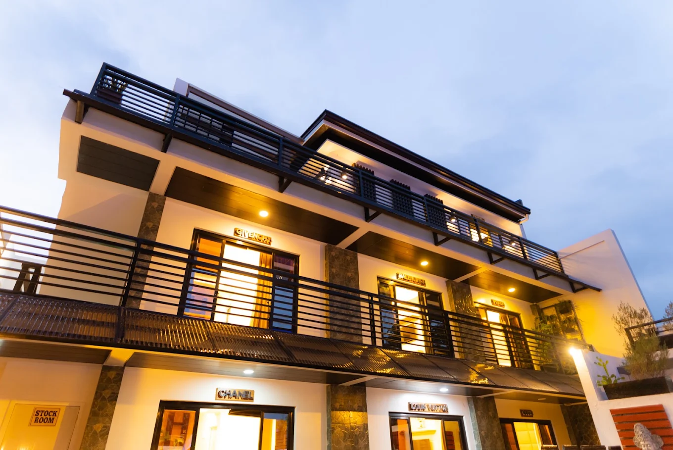 Modern facade of Villabong Resort in Imus, featuring illuminated balconies and stylish architecture at dusk.
