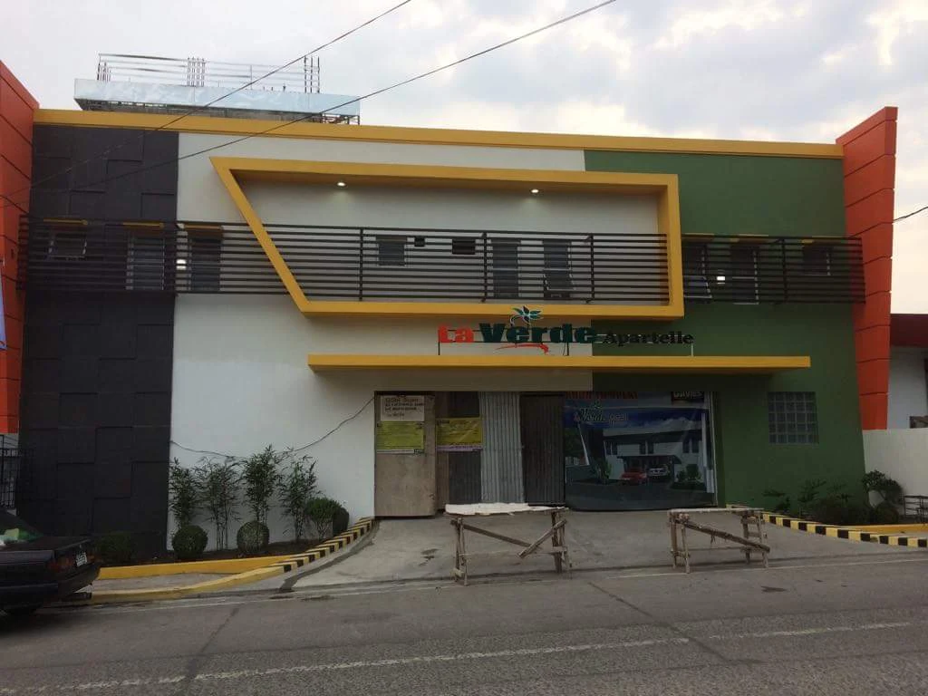 La Verde Apartelle in Bacoor, featuring a modern facade with green and orange accents and a landscaped entrance.