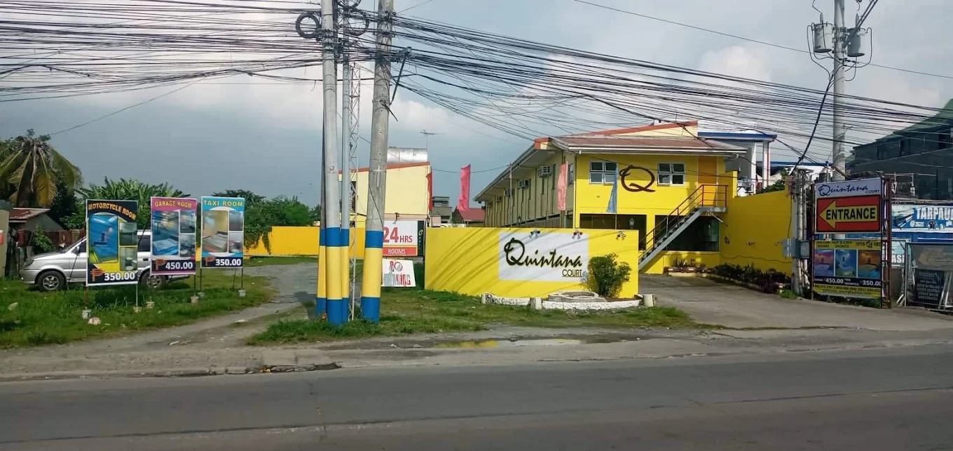 Quintana Court in Bacoor, featuring a bright yellow building with signage and room rate posters by the entrance.