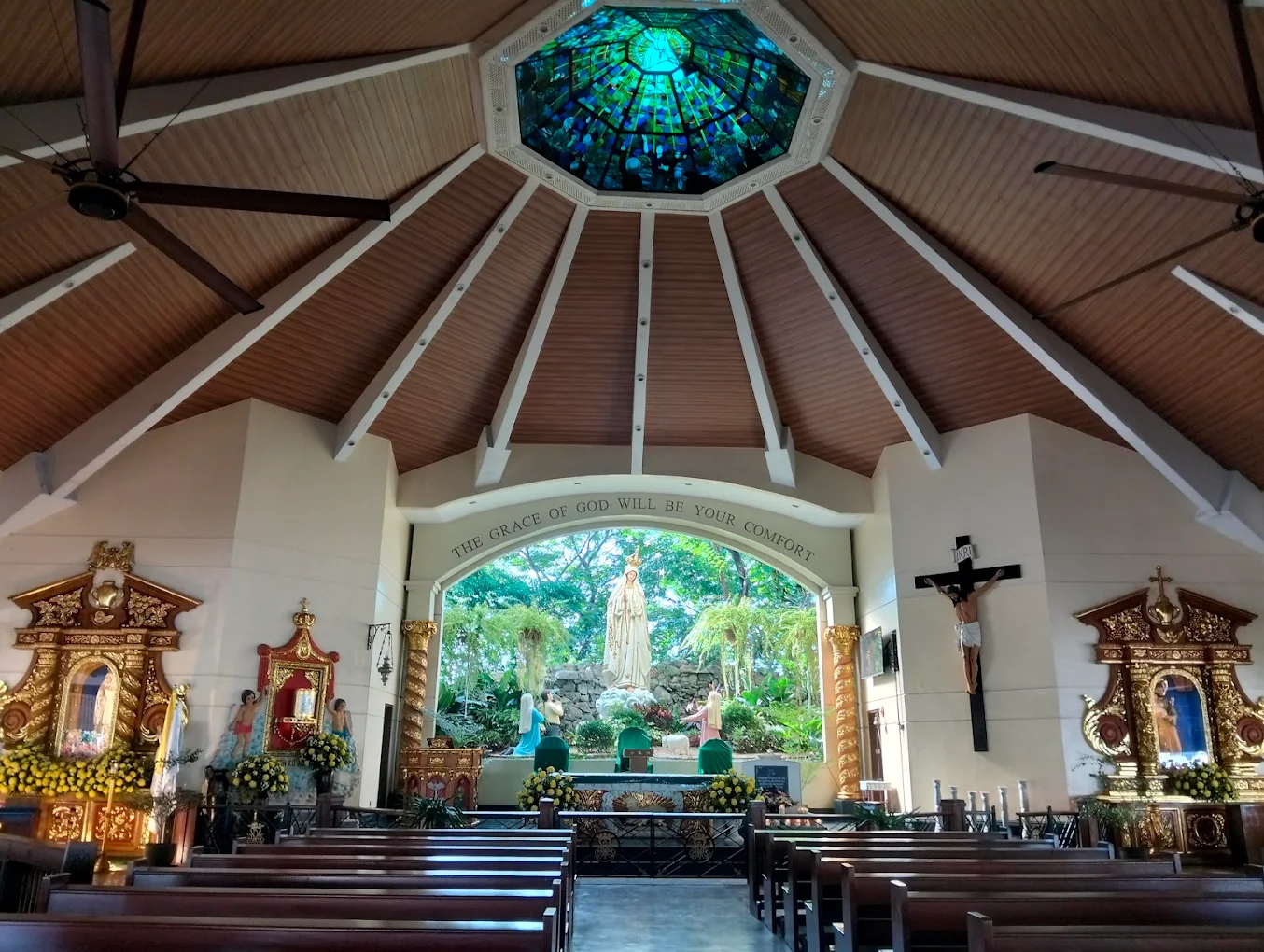 Interior of Diocesan Shrine and Parish of Our Lady of Fatima in Kawit, featuring altar and stained glass ceiling.